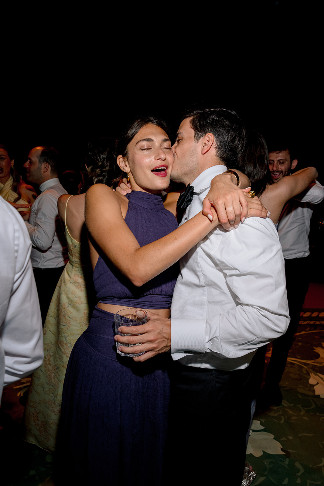 Wedding guests embracing and kissing on the dance floor at Villa Baulieu